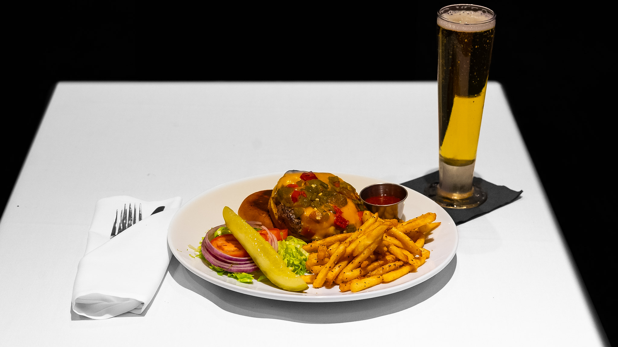 Plated cheeseburger and fries with a full table setting at Vintage 423