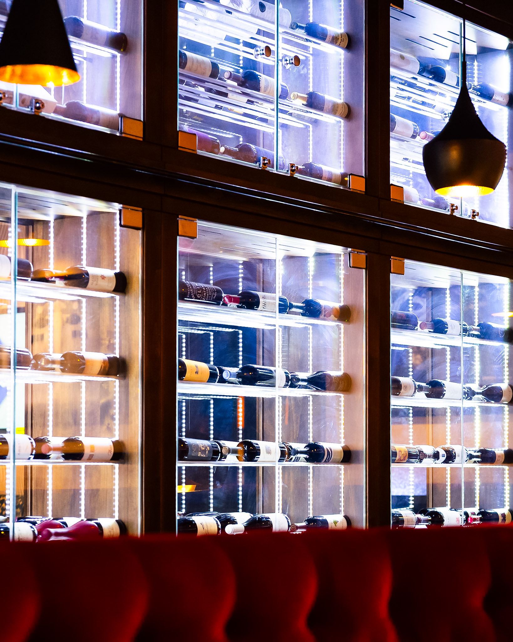 Illuminated wine wall lined with bottles at Vintage 423